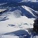 Der Gipfelsteinmann auf dem Piz Danis (2497m) mit Sicht hinunter auf den mit einer Bergbahn erreichbaren Piz Scalottas (2321,1m).
