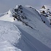 Der Gratbuckel P.2822m muss mit Ski südlich (links) umgangen werden, sonst bewegt man sich stets auf dem Südostgrat bis unter den Gipfelaufbau. Im Hintergrund ist der Gipfel des Piz Tomüls / Wissensteinhorn (2945,9m) zu sehen.