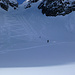Während die Skifahrer sorgfältig den Hang zeichnen, bearbeitet ihn der Snowboarder mit etwas breiterem Pinsel