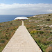 Unterwegs zwischen Ħaġar Qim und Mnajdra - Ein breiter Weg führt zur überdachten und deshalb aus der Ferne eher futuristisch als prähistorisch anmutenden Tempelanlage Mnajdra.
