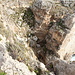 Miġra l-Ferħa - Blick vom Klippenrand in die Schlucht. Weiter oben sind einige Stufen zu erkennen. In Bildmitte ist die seitlich (rechts) einmündende, schmale Schlucht zu erahnen. Ganz rechts ist auch ein kleines Stück vom Meer zu sehen.