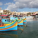 Am Hafen von Marsaxlokk - Im Hintergrund ist auch das Markttreiben an der Promenade zu erahnen.