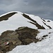 Das Gipfelkreuz lugt über den verschneiten Gipfelbereich.