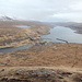 Im Aufstieg zum Eiðiskollur - Rückblick kurz nach Erreichen des Gipfelplateaus. Östlich (links) der Meerenge Sundini befindet sich die Insel Eysturoy, westlich (rechts) Streymoy. Oberhalb des Ortes Eiði ist der See Eiðisvatn zu sehen, daneben die LORAN-C-Sendestation.