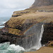 Gásadalur - Blick zum Wasserfall Múlafossur. Bei nachlassendem Sturm geht der Wasserfall wieder in seine "normale" Form über, und auch der Regenbogen zieht sich - wie abgeschaltet - sofort zurück ...