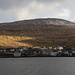 Sørvágur - Ausblick zu einigen Häusern auf der gegenüberliegende Seite des Sørvágsfjørður. Kleine Wolkenlücken lassen hier sogar kurz die Abendsonne durch. Foto während eines Zwischenstopps nach  der Tour.