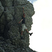 Sven hängt mit einer Hand am Gipfelaufbau des Morra de Lechugales.