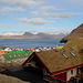 In Gjógv - Ausblick über den Ort vom Gjáargarður aus. Jenseits der Meerenge Djúpini ist die Nachbarinsel Kalsoy zu sehen, noch weiter hinten ragen auch einige schneebedeckte Berge von Kunoy heraus. Foto vom 28.04.2013.