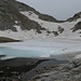 Lago Ledù ancora parzialmente ghiacciato e alle spalle la bocchetta del Cannone