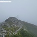 Unvermutet taucht das Gipfelkreuz des Pfaffenstein aus dem Nebel auf