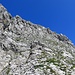 Aufstieg zum Gipfel schräg durch dieses Schrofengelände (I). Die Steilstufe oben überwindet man durch einen kurzen Kamin (II).