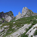 Auf der Höhe des Klettergartens. Auf der nächsten Stufe liegt der kleine Alpbetrieb Schrenit. Im Hintergrund von links Teile des Schwarzkopf, die Scherenspitzen und der Gamschopf.