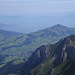 Hinter den Felsbastionen der nördlichen Alpsteinkette und dem Fähnerenspitz breitet sich das Rheintal aus. Am linken oberen Bildrand erhebt sich die Pfänderkette über dem Bodensee 