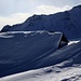 Der windgeformte Schnee versteckt die Hütte - hinten Piz Toissa (2657 m).