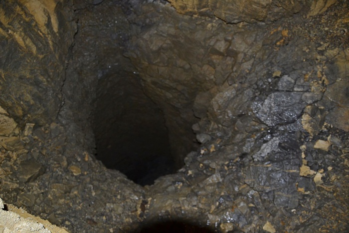 Sehr tiefes Loch in der Höhle. Mit ausgestrecktem Arm Sehr tiefes Loch in der Höhle. Mit ausgestrecktem Arm