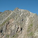 Hier geht auf etwa 2400m der steile Wiesen- und Schrofenhang in den blockigen Ostgrat über; oben sieht man den Gipfelbereich der Grinbergspitze.