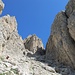Nach dem Aufstieg über Wiesen geht es etwas steiler in die Geröllrinne hinein und aufwärts bis an deren Ende unter die Kleine Cirspitze (neben deren markanter Kante führt der rißartige Rudiferia-Kamin auf die Kleine Cirspitze; links die Westliche Cirspitze).