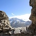 Blick durch ein Felsenfenster auf die Berner Gipfel.