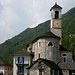 Kirche von Lavertezzo - dem geübten Betrachter sticht das Wirtshausschild links nach der Brücke ins Auge