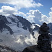 Gipfelsteinmann auf dem Piz Casnil gegen die Eiswand des Cima dal Cantun