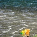Einsame Spielsachen am Ufer widerstehen kleinen Wellen