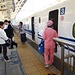 Das Reinigungspersonal besteigt den Zug, derweil die Passagiere auf den am Boden markierten Stellen warten