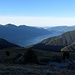 die Alpe Bardughè noch im Schatten liegend, während die Gegenhänge und Teile des Lago Maggiore bereits ins Sonnenlicht getaucht sind