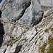 In der Verschneidung dan der einzige Steinmann im Aufstieg. Bei diesem kann über ein Band und den Felsspalt überraschend einfach auf die Wiesenfläche des Blühnbachtörls gequert werden.