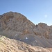 Face W du Triglav. Des vires cablées permettent de rejoindre la brèche évidente au pied de l'arête sud. Détails