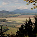 Kamenický kopec (Kamnitzberg) - Ausblick unweit der Abbruchkante zum ehemaligen Steinbruch. Durch eine Lücke im Blätterdach des Waldes sind einige etwa nördlich gelegene Bergkuppen zu sehen.