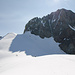 Übersicht des Gipfelaufbaus der Aig. des Glaciers. Der Aufstieg erfolgt von links kommend zunächst bis zum Übergang Eis/Fels, dann nach  schräg rechts oben bis in die erste Scharte rechts vom Westgipfel (kleiner Turm in der Bildmitte im Grat) und dann den Grat entlang bis zum Gipfel (3 SL, II-III).