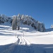 Über glitzernden Schnee geht es hinauf zur Riesenhütte, sie liegt hinter dem markanten Waldsattel am rechten Bildrand.