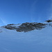 Normalerweise erfolgt der Aufstieg zum Vorgipfel mit Ski über die Steilstelle (rechts). Mangels Schnee mache ich heute Skidepot in Gratnähe und steige zu Fuss über den Sommerweg hoch (links).