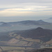 Milešovka - Ausblick aus dem Gipfelbereich. Dunst und Nebel wabern durch die niedrigeren Teile der Landschaft.
