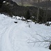 Schöne Spur auf dem Bergweg. Skifahrer bleiben runterwärts auf dem breiten Alpweg