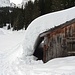 Die schwere Schneelast gleitet vom Dach der Lochhütte