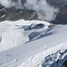 Tief drunten der Hohlaubgletscher - der Zustieg aus der Metro Alpin erfolgt am linken Rand oberhalb der Spaltenzone. Von dort aus quert die Spur das Gletscherbecken nach rechts hinüber zum Hohlaubgrat, der oberhalb der Felsköpfe erreicht wird.