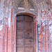 Alla chiesa si accede dal chiostro trmite un ingresso laterale decorato da formelle invetriate.