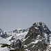 Der mächtige Felsdom des Piz Buin beherrscht die Szenerie, dahinter öffnet sich zwischen Plattenhörner und Chapütschin ein Fenster in die Adula-Alpen