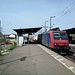 Eine Re 482 der SBB Cargo donnert mit einem langen Güterzug durch den Bahnhof von Haltingen.