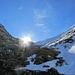 Die Sonne blinzelt in die Rinne. Die Wächte oben konnte man umgehen. Um sie zu übersteigen hätte man zumindest einen Pickel gebraucht. Ob die Wächte bei starker Erwärmung einfach abschmilzt oder evtl. abrutschen könnte, vermag ich nicht zu beurteilen.