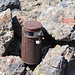 The small container with the summit register, a glass jar encased in a rusty tin can. It's old...