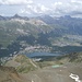 Blick vom Piz San Gian hinunter zum vorgelagerten Piz da l'Ova Cotschna. Im Tal St. Moritz mit dem See, Celerina und Samedan. Ganz im Hintergrund der spitzige Piz Ot und der flache Piz Kesch.