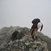 Nach leichter Kletterei im Nebel und bei einem Regenschauer am Gipfel angekommen