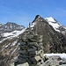 Ometto di sasso sulla quota 2209 m. Sullo sfondo la cresta W della Cima di Piancra bella