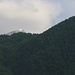 Vom Hotel Mladost in Tjentište zeigt sich der höchste Bosnier Mali Maglić / Bosanski Maglić (2386m) knapp über dem Wald. Rechts im Vordergrund steht der bewaldete Hügel Beškita (1275m).