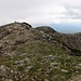Rückblich vom Gipfelkreuz zum Vermessungsstein der Dinara (1831m). Der Stein ist der höchste Punkt der Dinara und der Landeshöhepunkt Kroatiens.
