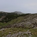 Blick zurück vom Gipfelkreuz auf der Dinara (1831m) auf den obersten Aufstieg über den teilweise mit Legföhren bewachsenen Kamm.<br /><br />Der felsige Gipfel ist der namenlose P.1698m welcher der Dinara in 1,8km Entfernung südlich vorgelagert ist. Am Osthang von P.1698m befindet sich das vom Gipfel nicht mehr sichtbare Wäldchen Gorica welches wir durchwanderten. Der Weg von Glavaš erreicht den Kamm aus der Flanke im Sattel vor P.1698m.