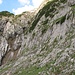 Vom Anseilplatz im Vordergrund leitet der untere Klettersteig durch die Platten in einer rechts-links-Schleife hinauf zum erkennbaren Grünen Buckel.
