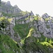 kühn angelegter Bergweg, sich auf steilen Grashalden zwischen Felswänden hochwindend ...